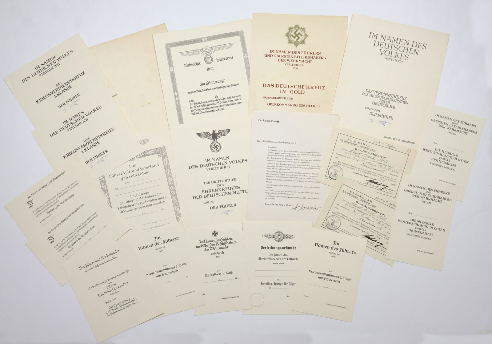 BLANK GERMAN AWARD DOCUMENTS (15): Lot of fifteen blank German award documents all contained within an NSDAP folder. The documents are for the awards: War Merit Cross, 1st Class with facsimile signature of Adolf Hitler (2); German Moth