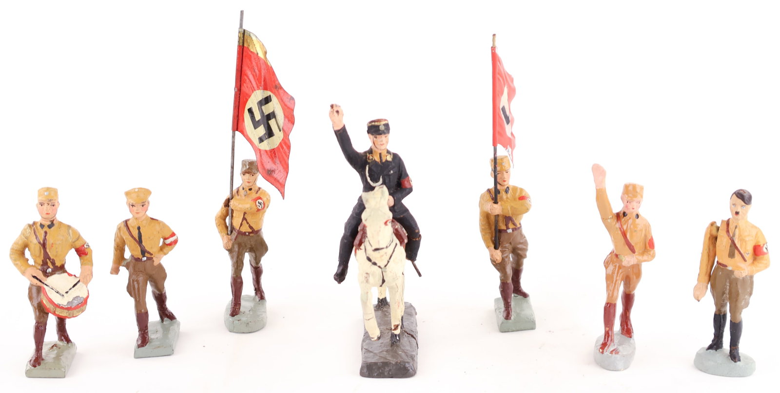 NAZI TOY SOLDIERS (7): A fine collection of seven Nazi figures dressed for parade, made by Lineol and Elastolin. Includes: a 3 in. figure of Hitler with his right arm hinged to give the Nazi salute, a 3.25 in. figure giving