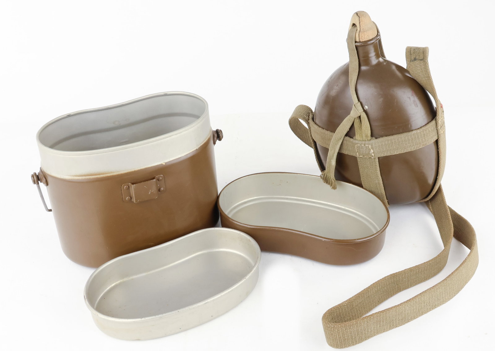 JAPANESE CANTEEN AND MESS KIT: Well-preserved Japanese Army canteen and mess kit with the original wooden cap and straps. There is also evidence of a name on the back, but it is obscured by some white paint. Fine. The mess kit is i