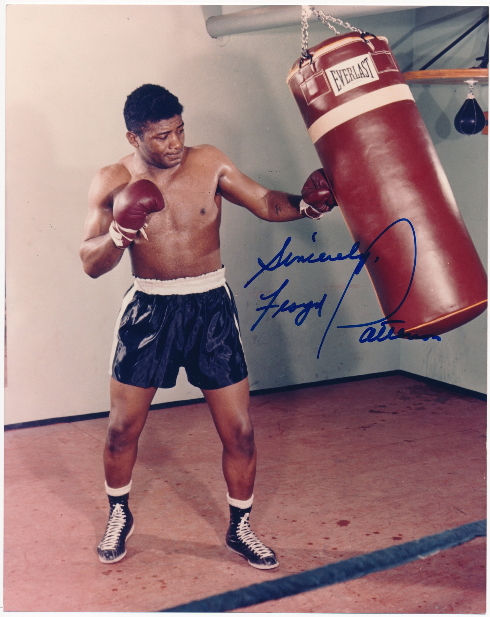 FLOYD PATTERSON: (1935-2006) American heavyweight boxing champion, the first to regain a title after losing it. S.P., 8 x 10 in. color, showing Patterson practicing on a punching bag. Boldly signed at the right in blu