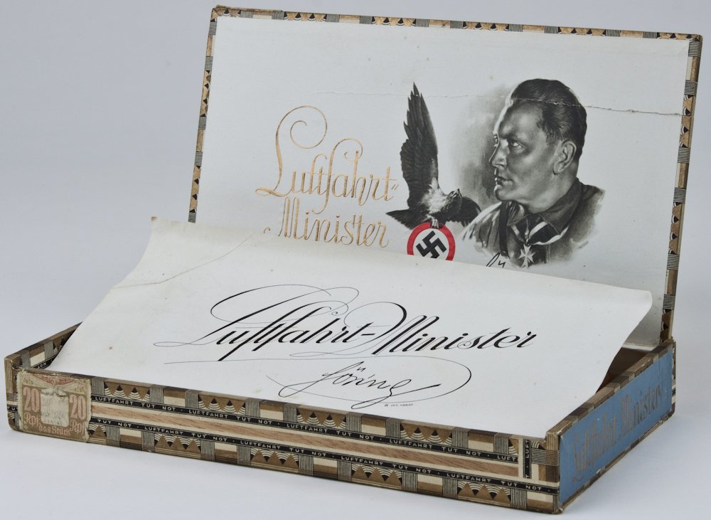 HERMANN GOERING CIGAR BOX: An unusual relic from the Third Reich, a 9 1/4" x 5" x 1 1/8" "Luftfahrt Minister" brand cigar box honoring Luftwaffe Reichsmarshal Hermann Goering. The cedar box's top lid is lightly branded with the