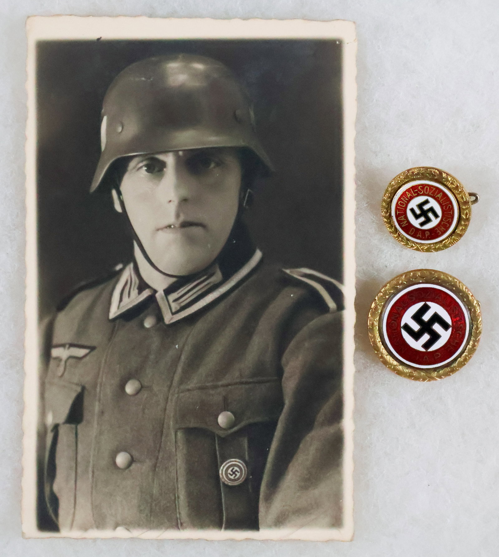 PAIR OF IDENTIFIED GOLD NSDAP BADGES (2) NAMED TO THE SAME MAN: An incredible pair of gold Nazi party badges, both numbered to the same party member. The badges display a gold laurel wreath hollow brass base, backing the original design party pin with the ‘N