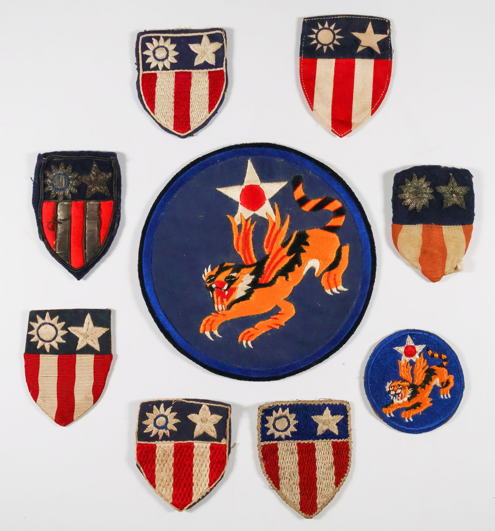CHINA-BURMA-INDIA SHOULDER AND JACKET INSIGNIA (9): Nine varied pieces of chest and shoulder insignia issued to fliers, crewmen and soldiers in the China-Burma-India theater of war. Generally very good.