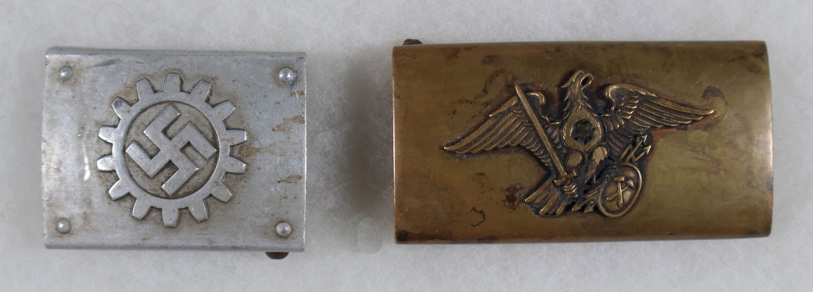 GERMAN BELT BUCKLES (2): A fine pair of belt buckles for Nazi workers’ organizations. Includes: a belt buckle showing the emblem for the DAF with the mark ‘M 4/24’, and a belt buckle with an eagle clasping a