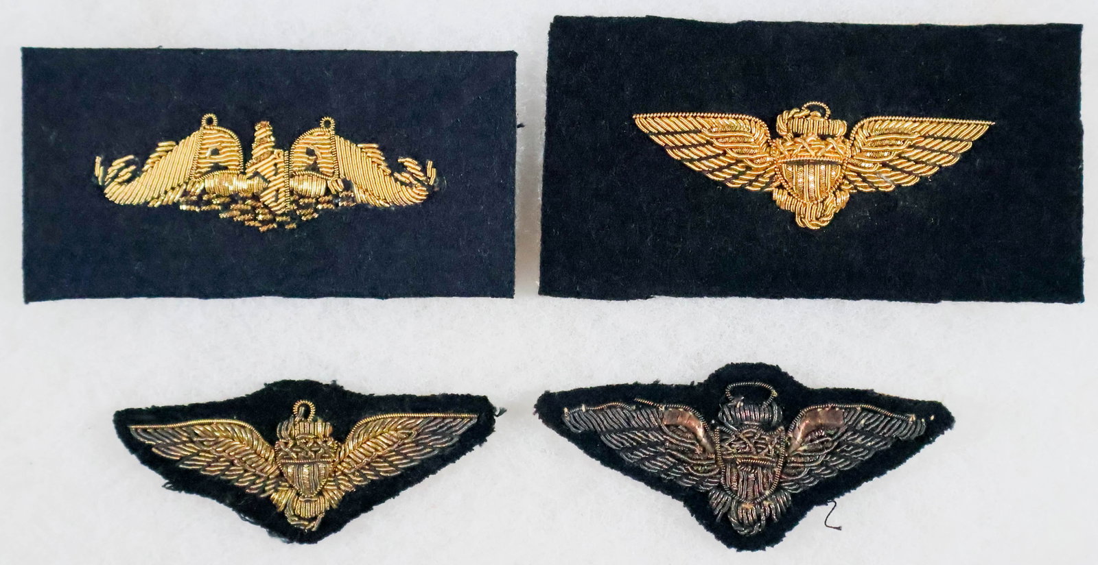 GOLD BULLION EMBROIDERED INSIGNIA (4): Lot of four pieces of gold bullion embroidered insignia, includes three sets of wings (two used), and a submariner's chest emblem. Fine.
