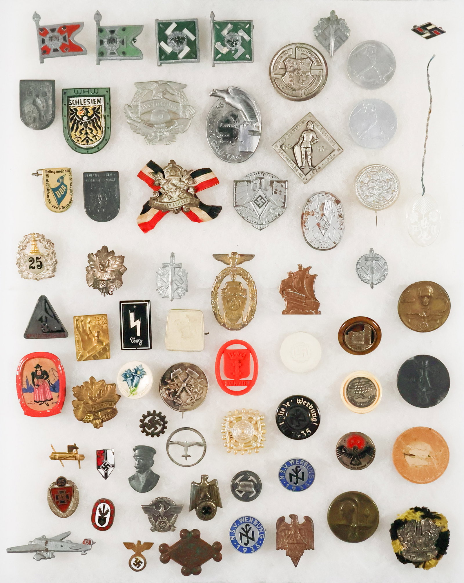 TINNIES, PINS, AND MISCELLANY (60): Balance of a collection, about 60 various pins, tinnies, Winterhilfswerk charms, etc., a good number lacking pins, a few good ones hiding among the riff raff. Should be seen.