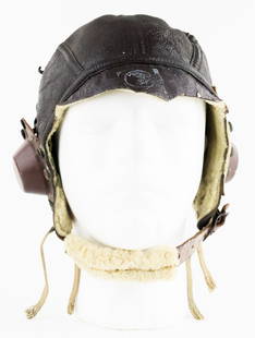 AMERICAN USAAF B-6 WINTER FLIGHT HELMET: An intact American B-6 style American flight helmet with the original wool lining and chinstrap. The earphones remain intact along with a white stamp on the front of the emblem of the Army Air Force.