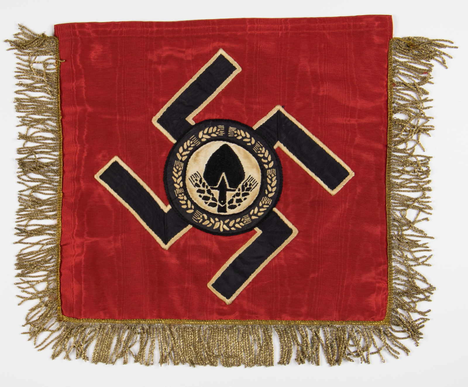 REICHSARBEITSDIENST BANNER: Reichsarbeitsdienst (R.A.D.) banner, 17 in. x 15.5 in., a high quality two-sided multi-piece red silk or rayon moire. An embroidered patch of great detail, bearing the emblem of the R.A.D. is embroide