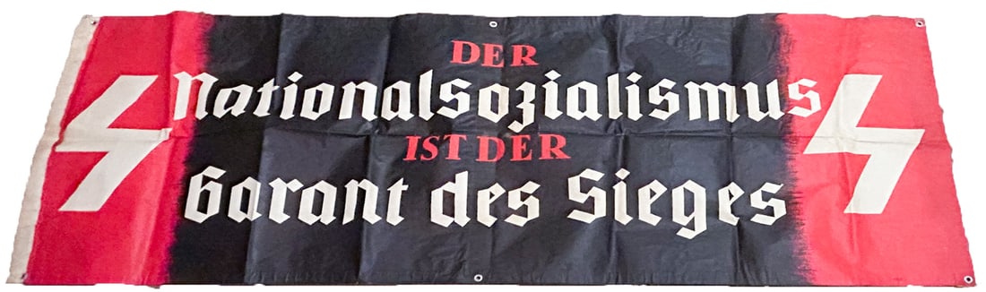 DEUTSCHES JUNGVOLK BANNER PRAISES NATIONAL SOCIALISM: Very rare weatherproofed heavy stock paper banner, 84 x 31 in., bears the message: 'National Socialism is the guarantee of Victory' with Deutsches Jungvolk runes at either end. Folds, else fine condit