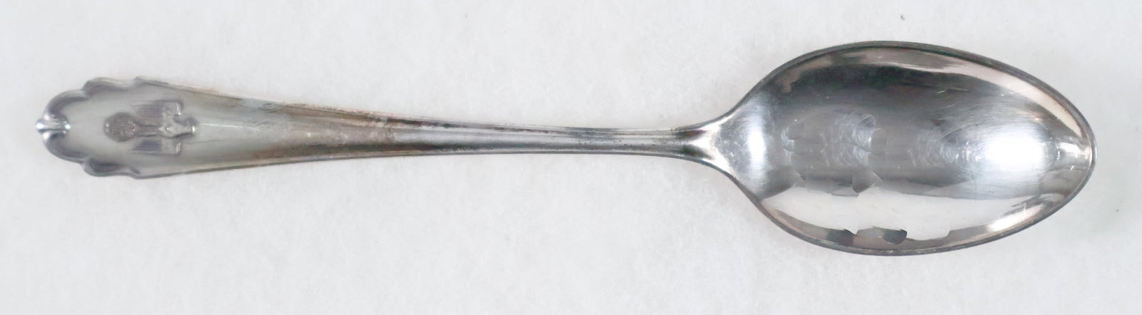 REICHS CHANCELLERY SOUP SPOON: A silver-plated dessert soup spoon once used in the Reichs Chancellery in Berlin, 7 1/8 in. long with a fluted design, the bottom bearing a left-facing eagle clutching a static swastika in high relief