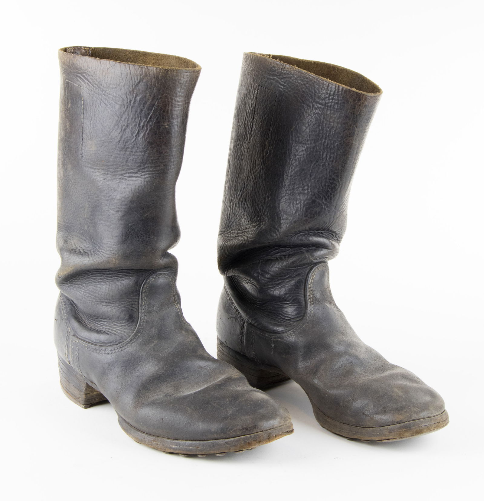 WEHRMACHT HOBNAILED BOOTS: A pair of Wehrmacht black leather boots, 12.5 in. tall, well-worn, each bearing multiple hobnails and steel heel reinforcements on the sole, distinctive of the boots worn by German soldiers.