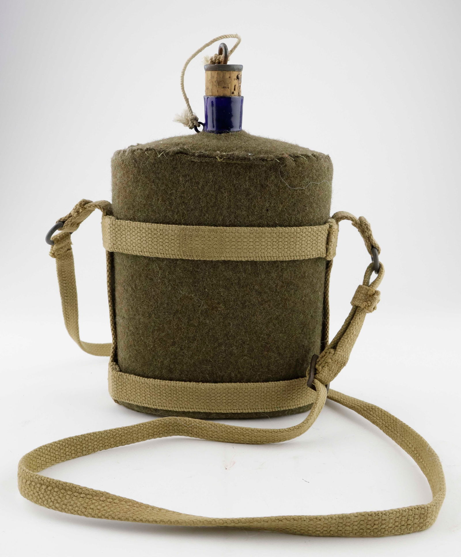 WORLD WAR I BRITISH ARMY WATER BOTTLE: Rectangular porcelain coated cobalt blue tin water bottle with a kidney-shaped cross section, approx. 5.5 x 7 in. of the type issued by the British Army during World War I. The mouth is fitted with a