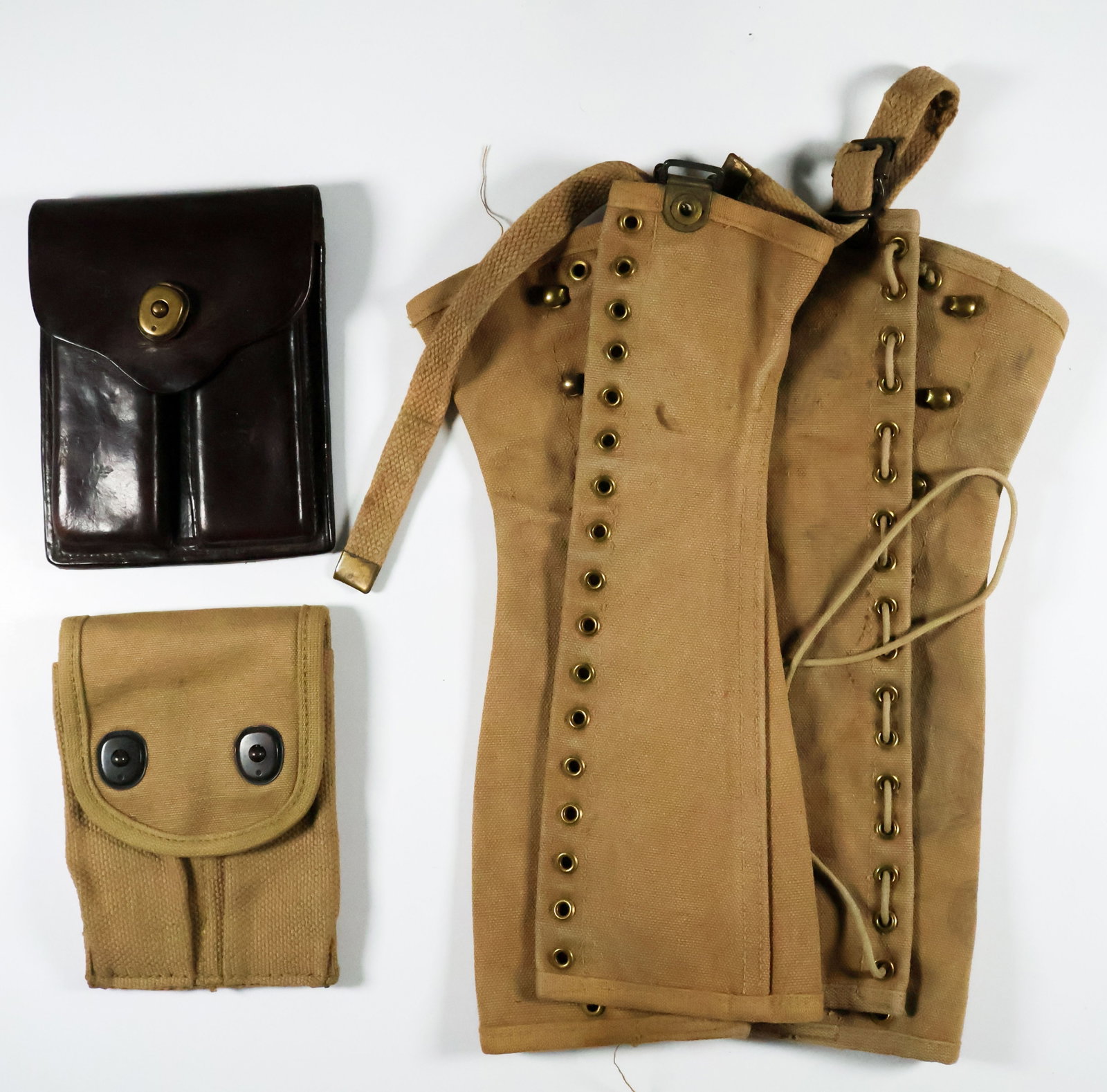 WORLD WAR I POUCHES (3): A fine collection of three World War I pouches. Includes: a Colt 1911 leather magazine pouch, a 1918 pistol magazine pouch, and canvas boot gaiters from 1918. Very good.