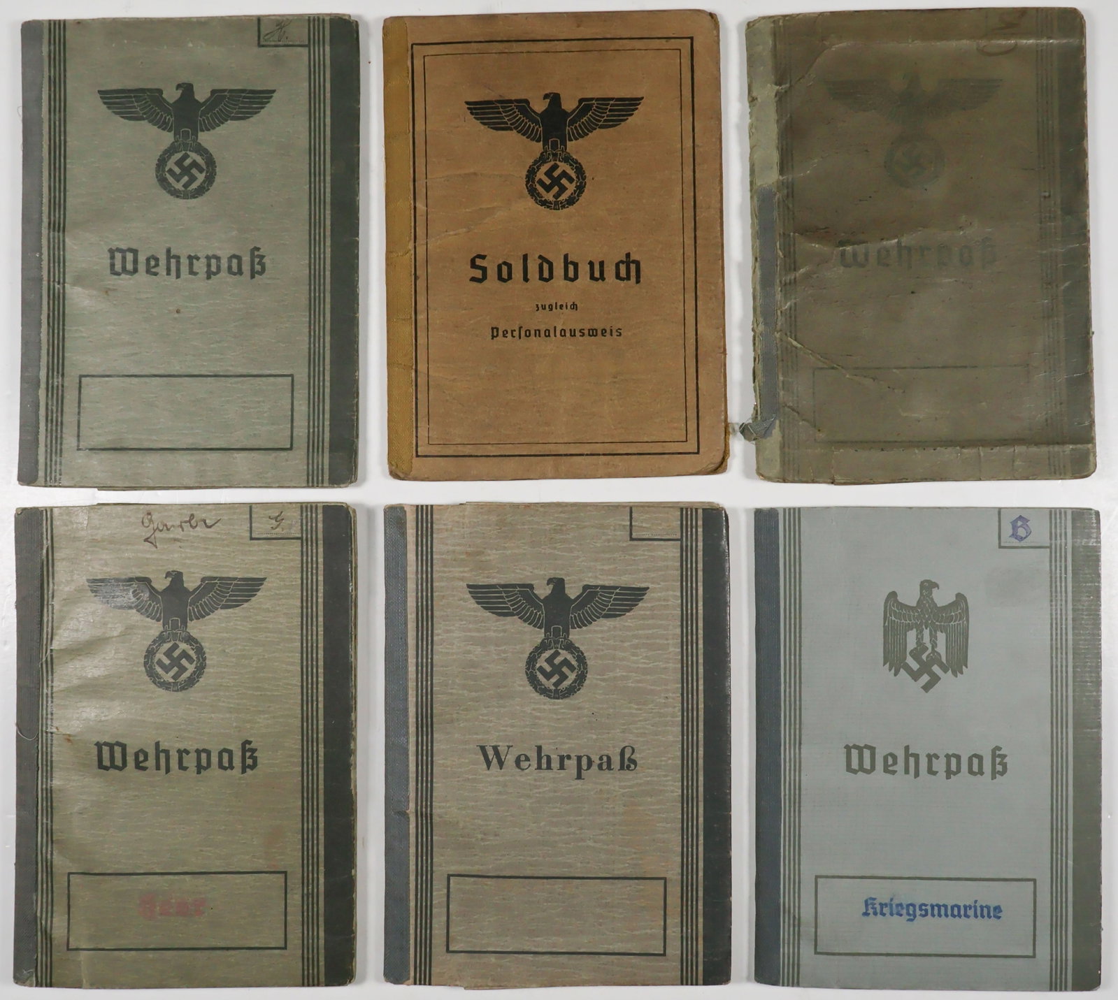 LOT OF SIX WEHRPASSES (6): Lot of six German-issue wehrpasses. The wehrpasses were issued to: a member of the Landeschutzen, a Kriegsmarine artilleryman, an unactivated 18 year old, a World War I veteran (lacking photo page), a