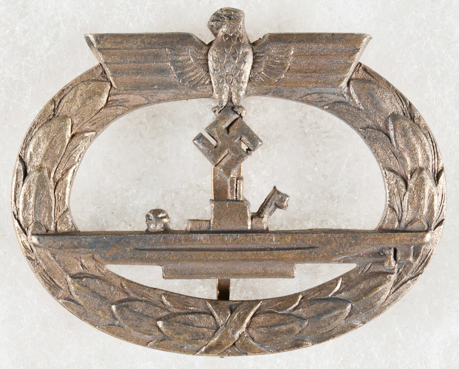 KRIEGSMARINE U-BOAT WAR BADGE: A fine example of the U-Boat War Badge, 43mm x 48mm, fire gilded tombac, unmarked. Gilding remains almost entirely intact. The badge depicts a U-boat with flag, with a laurel wreath surrounding it and