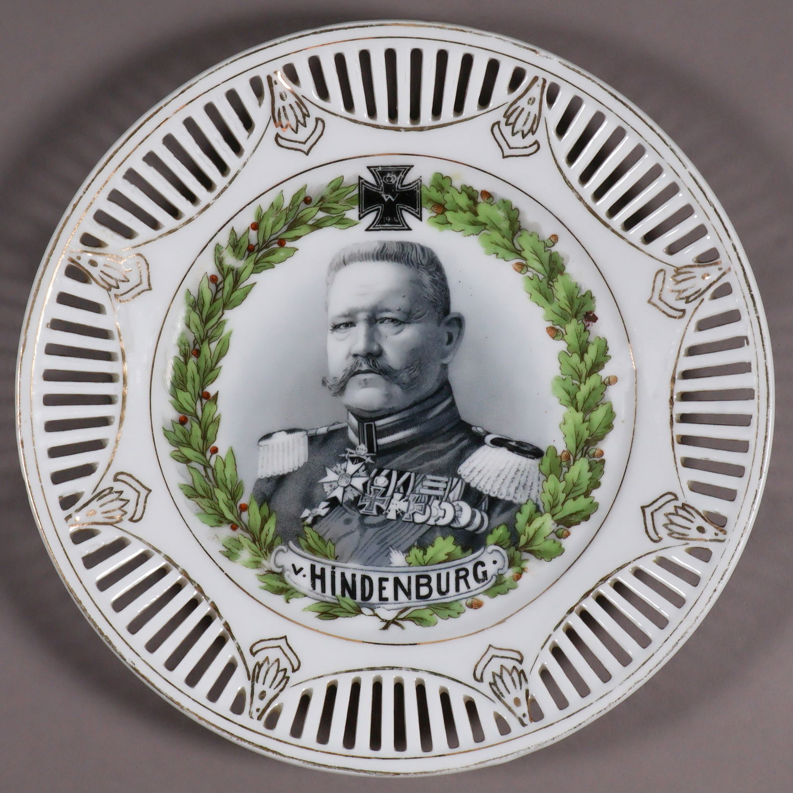 HINDENBURG COMMEMORATIVE PLATE: Nicely crafted porcelain plate commemorating German Gen. Paul von Hindenburg and picturing him in uniform at center, 7 in. diameter, the portrait surrounded by wreaths of laurel and oak leaved with an