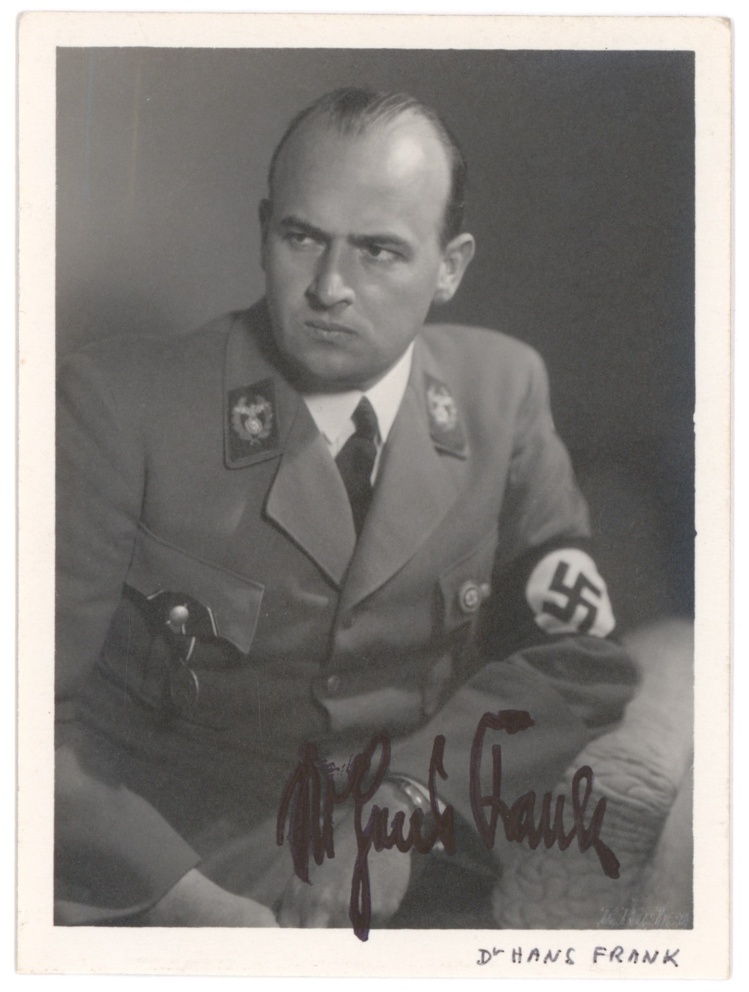 HANS FRANK: (1900 - 1946) Nazi occupational Governor of Poland partly responsible for the genocide perpetrated there. Rare war-date S.P. 3.5 x 4.75 In. b/w, a seated pose in uniform showing the stern-faced war