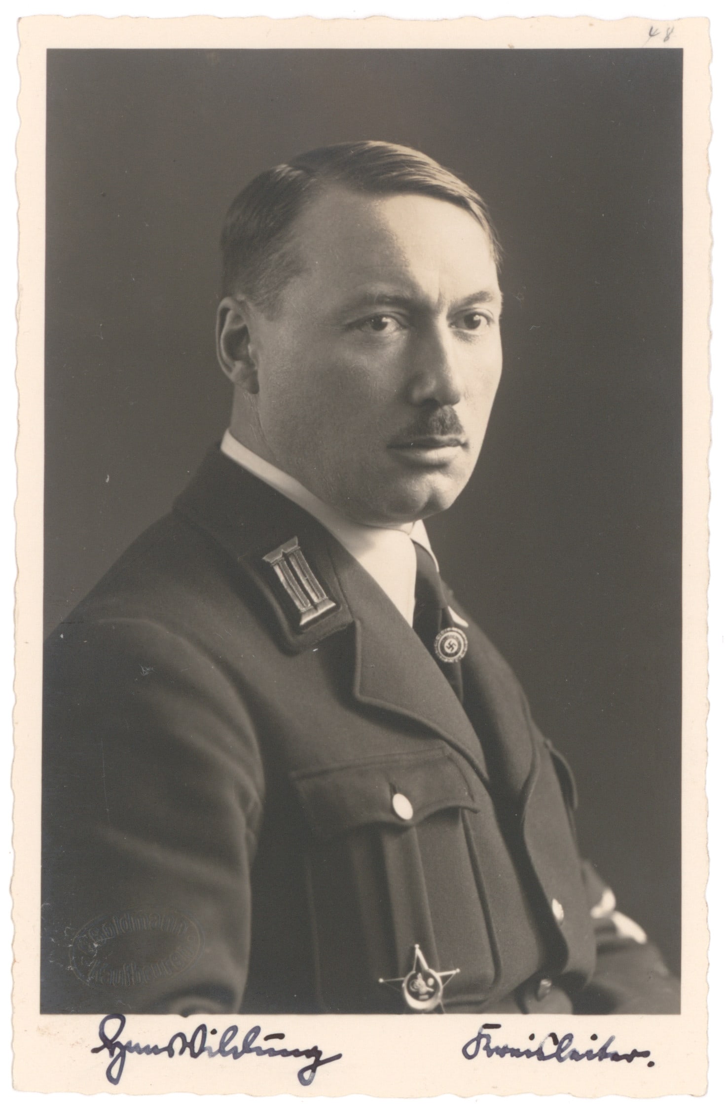 HANS WILDUNG: (1893 - 1943) Nazi Mayor of the large Kaufbeuren district, which also sponsored a euthanasia center. S.P. 3.5 x 5.5 in. b/w, a portrait in uniform with gold party badge, signed as Kreisleiter in