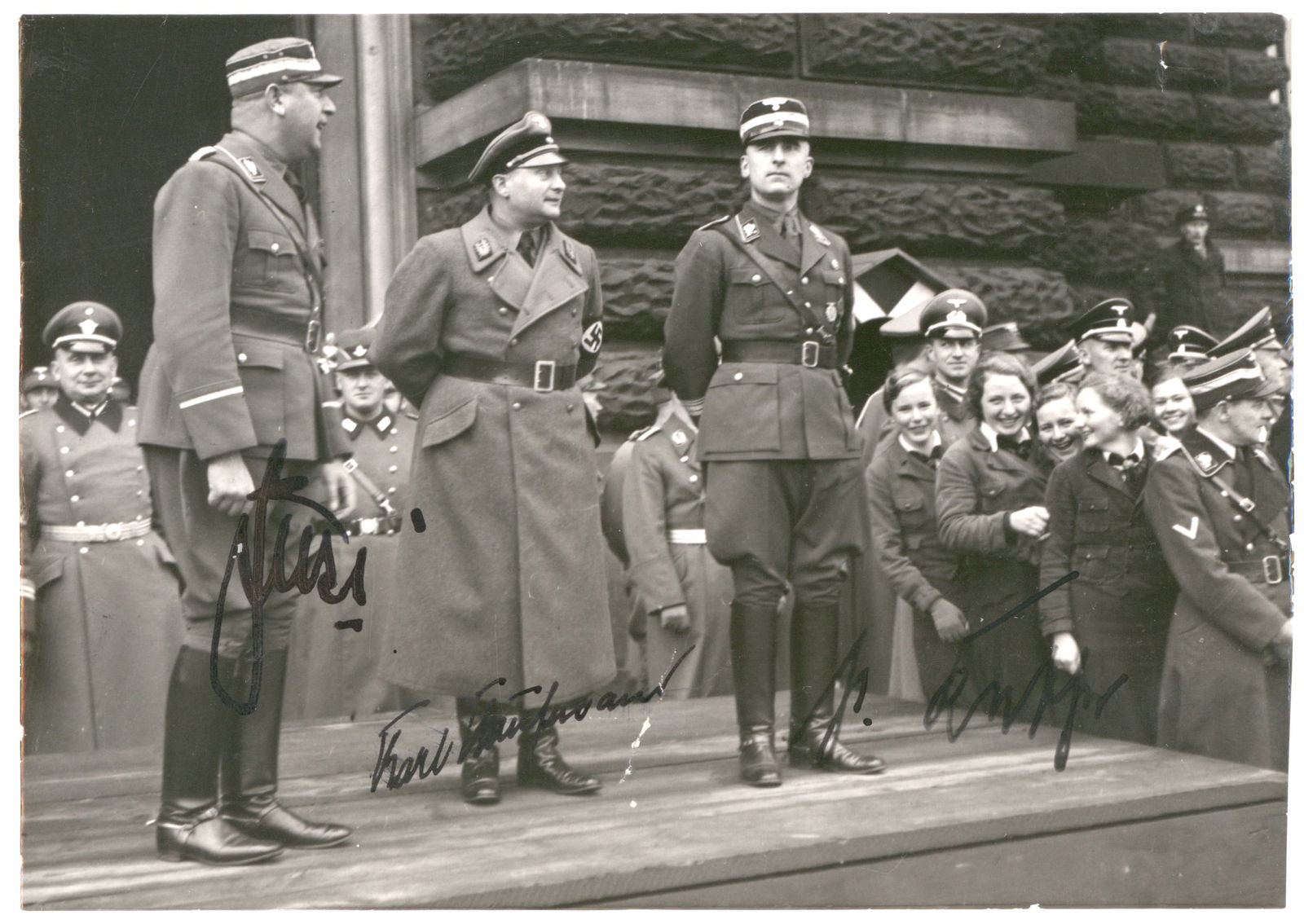 LEADING NAZIS OF HAMBURG: Rare press photograph signed by three leading Nazis originally based in Hamburg. The 6.5 x 4.75 in. b/w image shows three higher-level S.A. men standing atop a lecturer's platform, each signing beneat