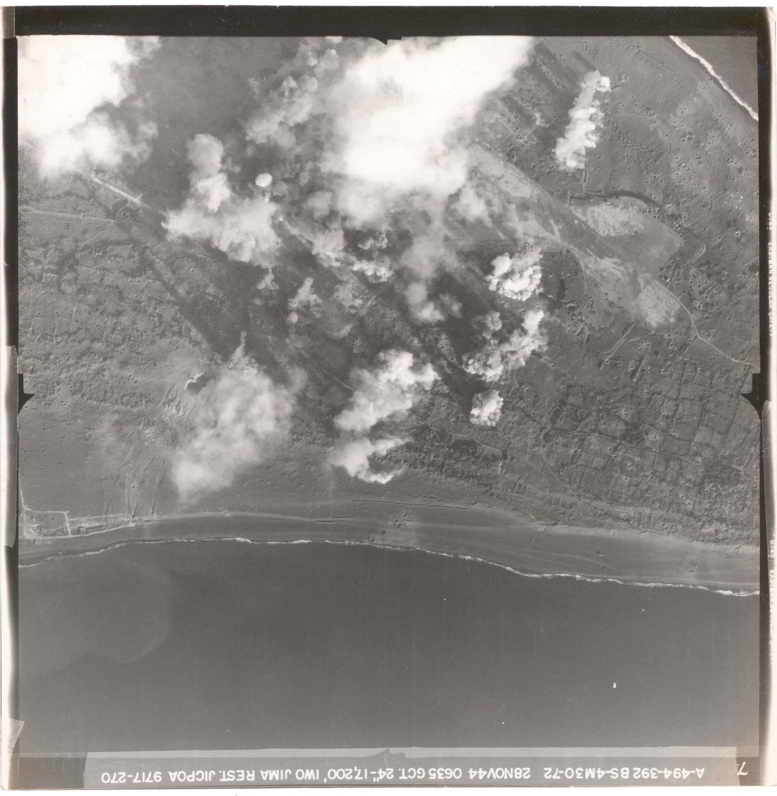 PRE-INVASION AERIAL PHOTOGRAPHS OF BEACHES AND BOMBARDMENT OF IWO JIMA (4): Fine lot of four original Army Air Force aerial photographs all taken just prior to the American invasion of Iwo Jima, three images showing heavy bombardment of Japanese fortifications on the island.