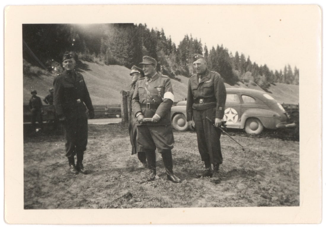 THE SURRENDER OF HERMANN GORING: An original photograph, 3.75 in. x 2.5 in. b/w, showing Goring upon his arrest, flanked by B. G. Hess and John E. Dalhquist. Very slight creasing, very good.