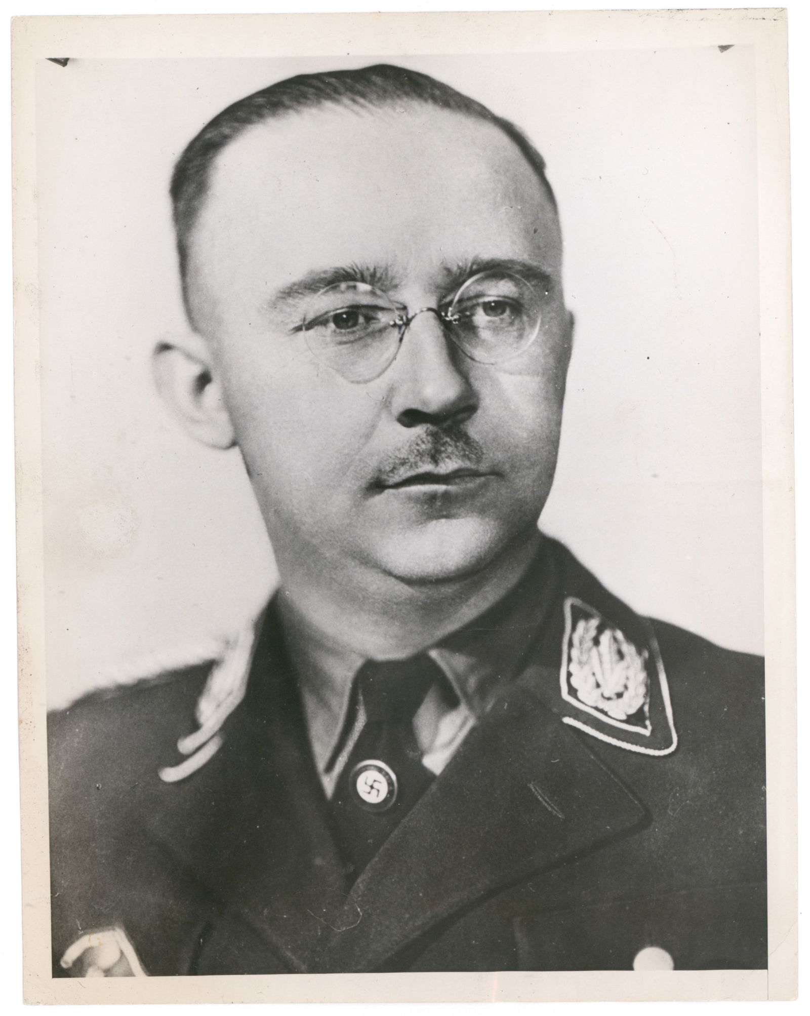 (HEINRICH HIMMLER): Two press photographs, the first showing Himmler in head and shoulders, 6.5 x 8.5 in. b/w. Very good. WITH: a second image showing Himmler greeting other Nazi leaders on an airstrip, 7 x 5 in. b/w,