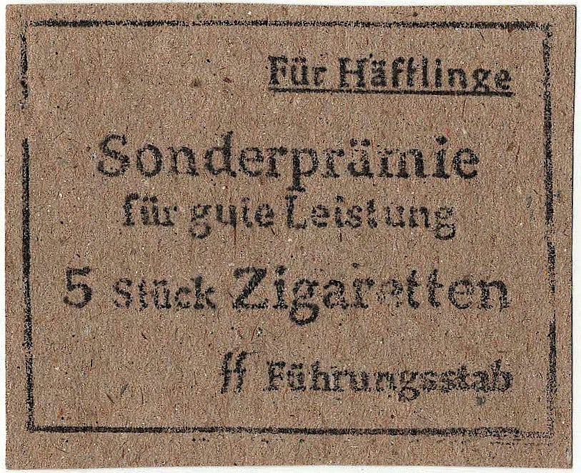 AUSCHWITZ PRISONER'S BONUS CIGARETTE SCRIP: Rare printed document5, 2pp. 2.75 x 2.1 in., a piece of scrip from Auschwitz reading: 'For Prisoners Special bonus for good performance 5 cigarettes SS Leadership Staff'. Verso bears a camp