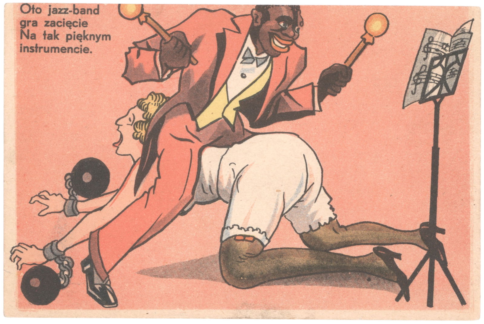 RACIST POLISH POSTCARD: A rare, pre-World War II racist postcard from Poland, 5.5 x 3.5 in. and depicting an African-American drumming on the backside of a blonde woman whose hands are held-down with balls and chains. The