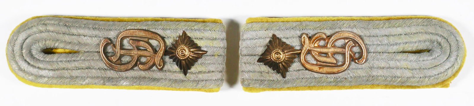 GROSSDEUTSCHLAND SIGNALS SHOULDER BOARDS: Scarce pair of Grossdeutschland Signals slip-on shoulder boards, each 4 in. long with silver wire-covered braiding on stiff yellow 'Signals' backing, brass 'GD' insignia, and one brass pip each. The