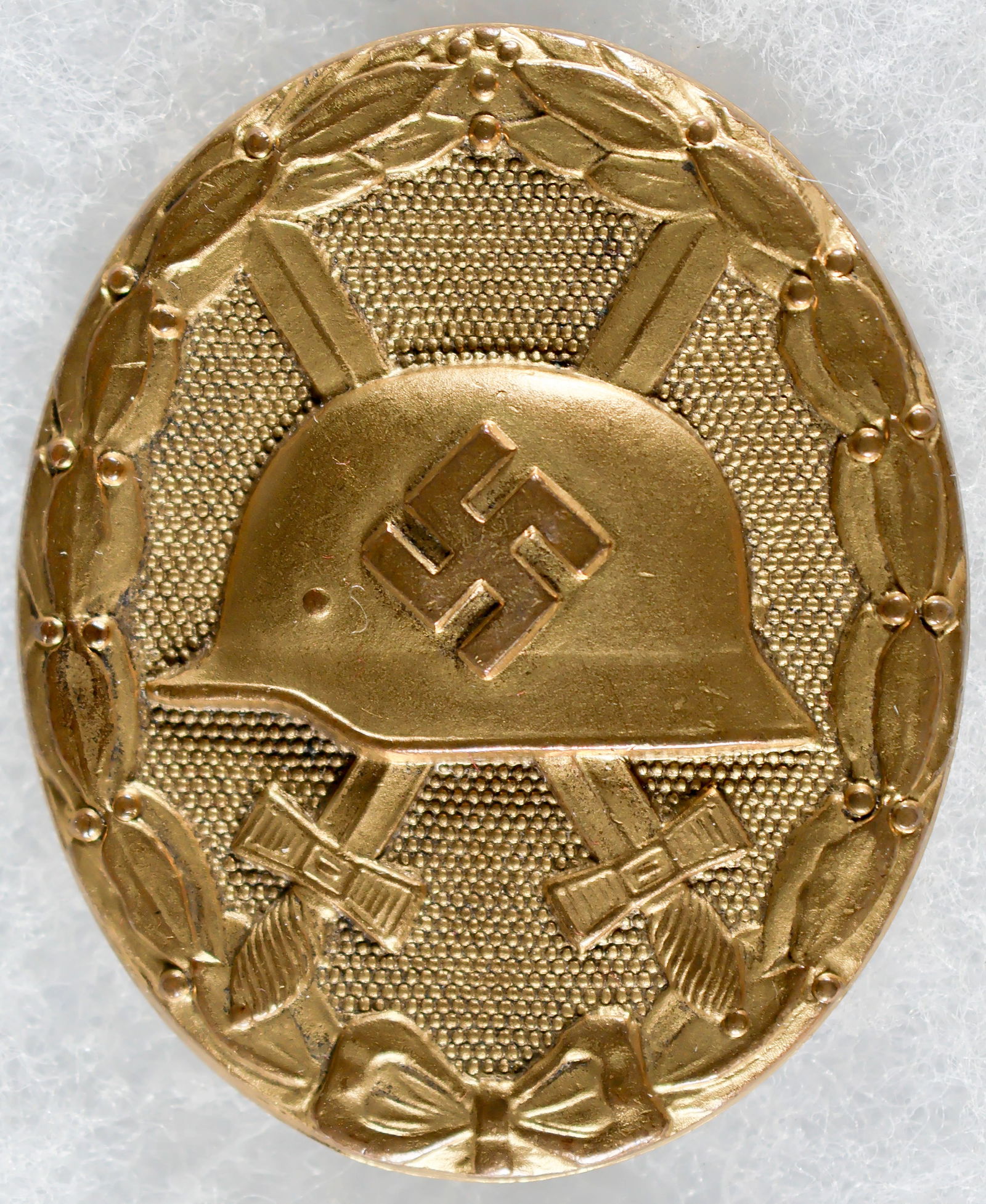 WOUND BADGE IN GOLD, CASED: Third Reich-era German Wound Badge in Gold (‘Verwundetenabzeichen’), of gilt tombac, unmarked but with pin-back catch indicative of maker Hauptmunzamt Wein. Housed in a padded maroon