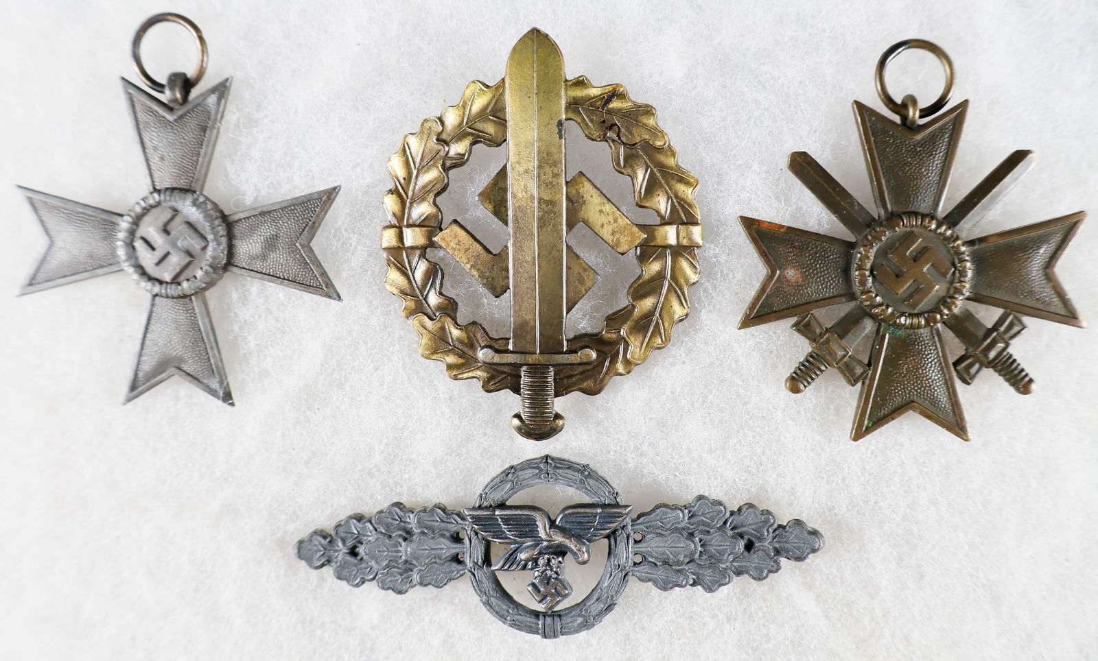 LUFTWAFFE TRANSPORT / GLIDER CLASP IN SILVER, OTHER MEDALS (4): Lot of four German Third Reich era badges and medals, including: a Luftwaffe Transport and Glider clasp in Silver, 76 mm wide and 26 mm high, showing an eagle in flight clutching a mobile swastika,