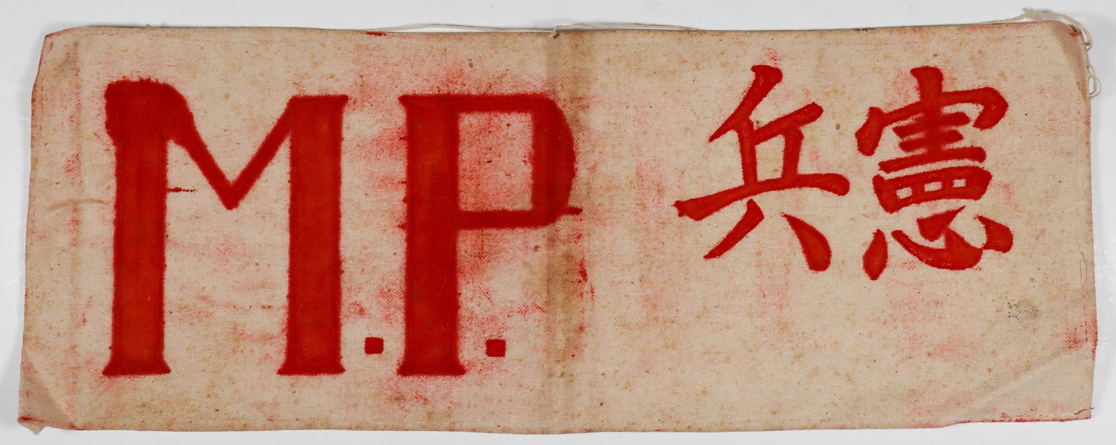 JAPANESE MILITARY POLICE ARMBAND: Very rare Japanese military police armband, white canvas 13.25 x 5 in. and hemmed on the inside. The lettering 'M. P.' and the Japanese 'Military Discipline' appears to have been stenciled in light