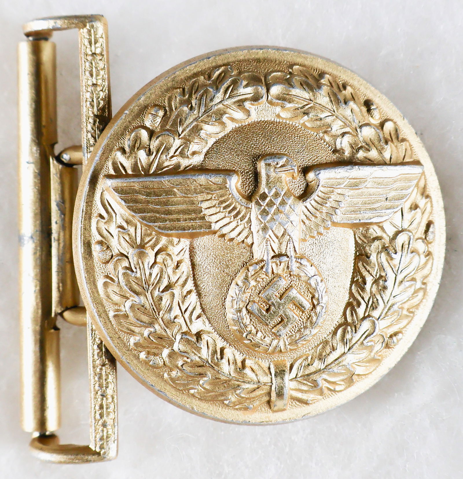 NSDAP POLITICAL LEADER'S BELT BUCKLE: NSDAP Political Leader's belt buckle, solid aluminum construction with gold wash, 2.25 in. wide, the reverse stamped by maker 'M4/24' for Friedrich Linden. Some high points on the surface are rubbed,
