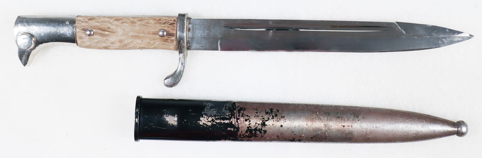WEHRMACHT DRESS BAYONET BY CARL EICKHORN: A Wehrmacht dress bayonet, 7.75 in. blade, 12.5 in. overall, with a silver-finished bird's head-style pommel fitted with a functional release catch. The grips are staghorn, with a turned-down teardrop