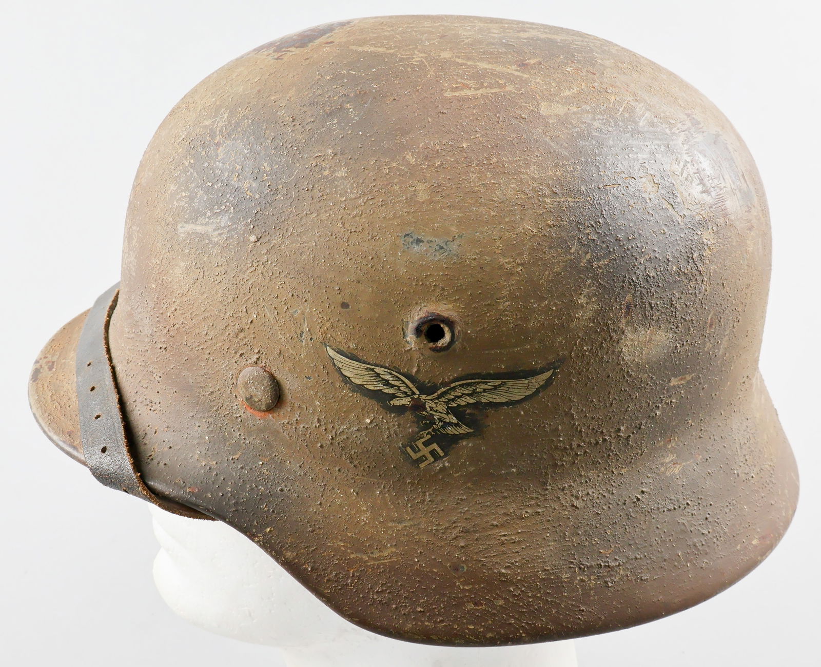 LUFTWAFFE CAMOUFLAGE M40 HELMET: A fine example of a German M40 single-decal combat helmet, featuring a Luftwaffe eagle decal on the left-hand side. The exterior of the shell is hand-painted overall with a three-color camouflage sche