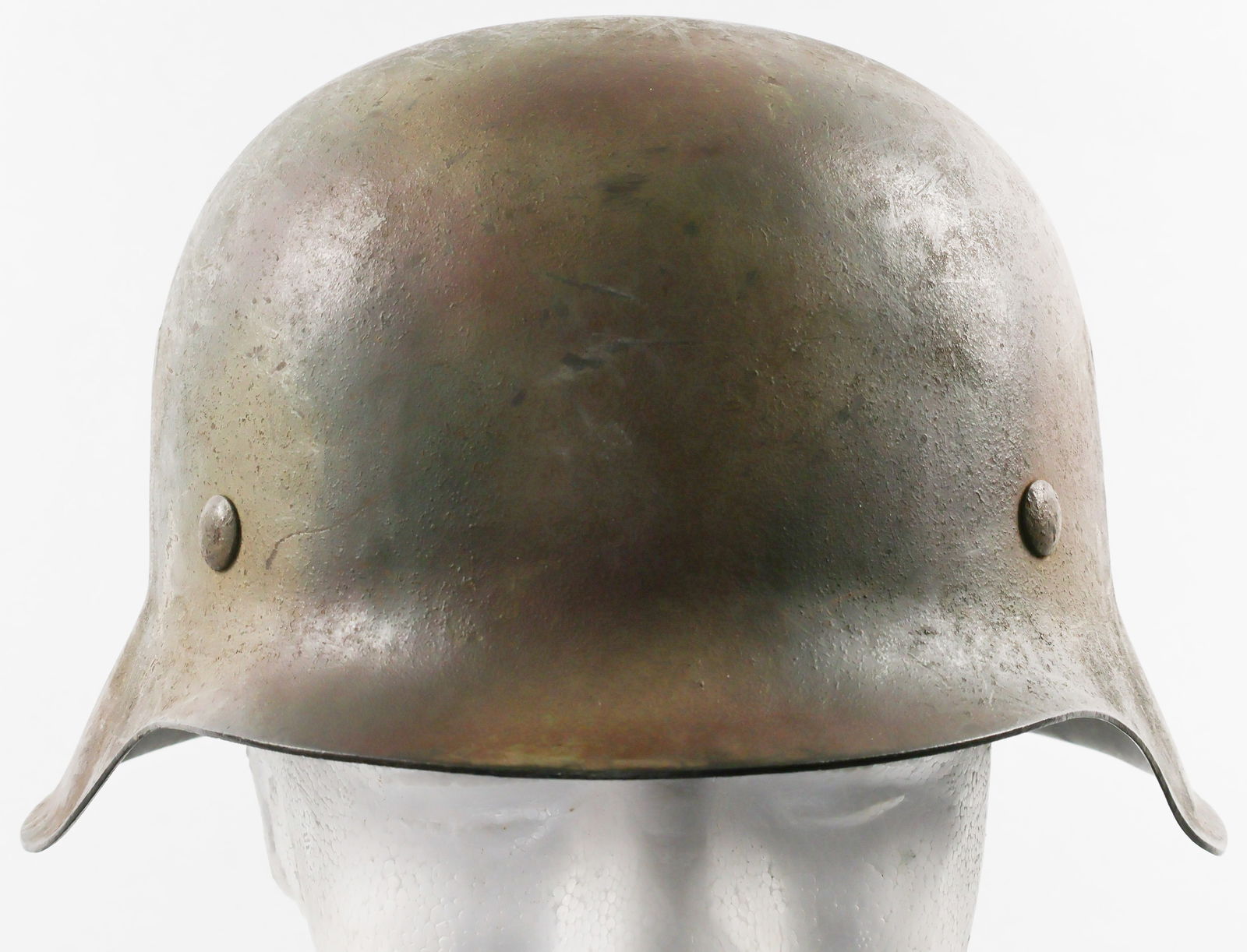 WAFFEN-SS CAMOUFLAGE M42 HELMET: Single-decal Waffen-SS M42 combat helmet, featuring a ‘Normandy’ camouflage scheme of green, yellow and brown paint. The right-hand side of the helmet faintly shows an SS runes decal beneath the c