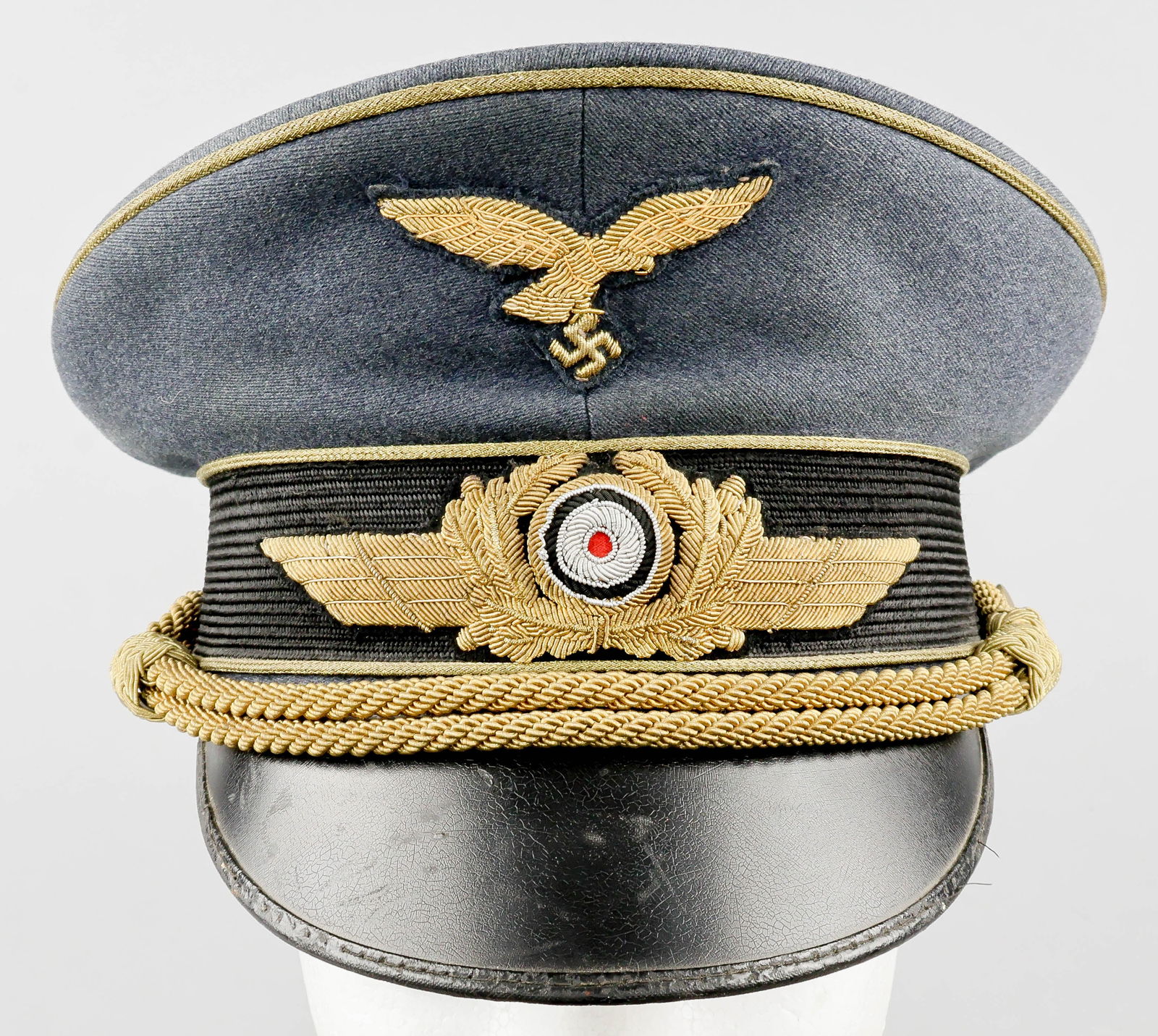 LUFTWAFFE GENERAL OFFICER'S VISOR CAP: A very fine and attractive Luftwaffe general officer’s visor cap, manufactured to an extremely high standard of quality, is constructed of grey-blue wool over a band of woven black mohair, with