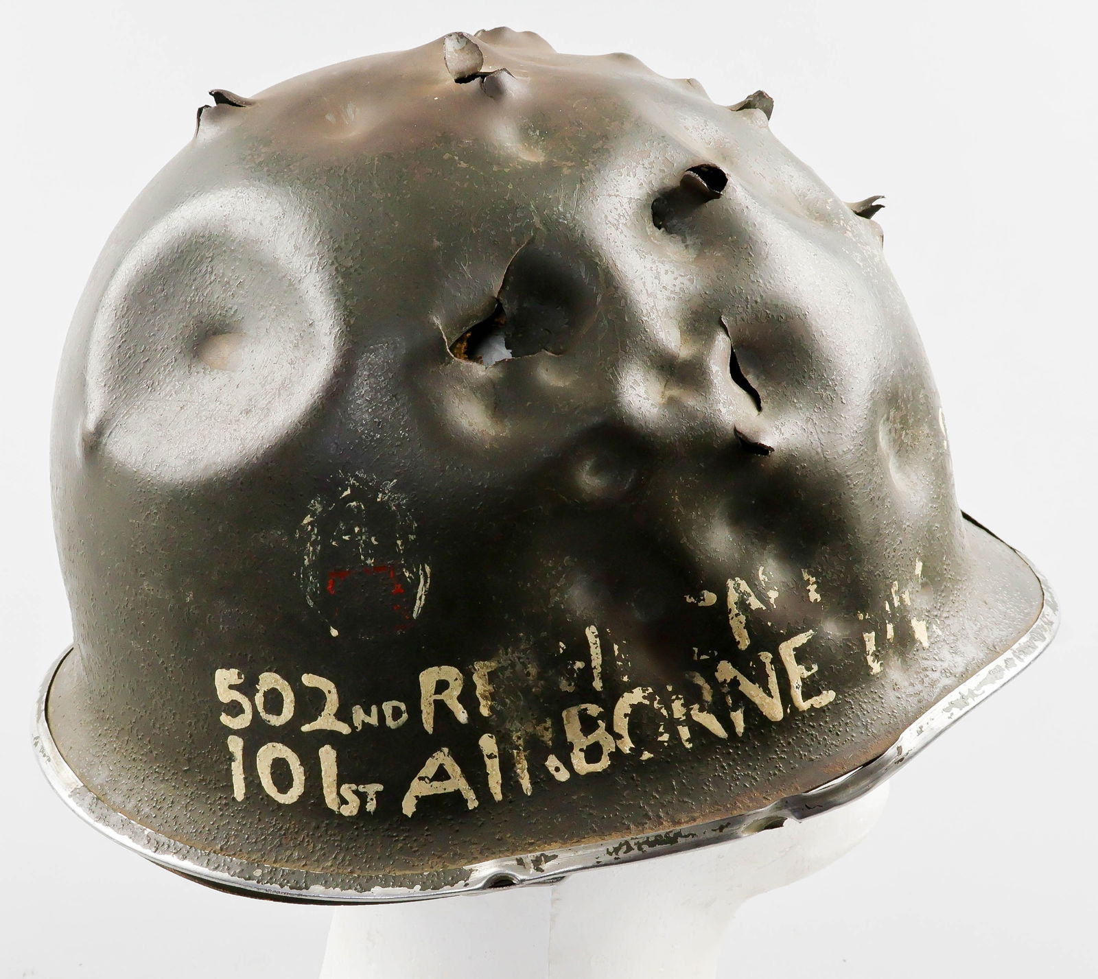 OPERATION MARKET GARDEN S-MINE DAMAGED M1 HELMET: A provocative relic of the American drive across Europe in the latter part of World War II, an early U.S. M1 front seam, fixed bale helmet, fitted with an International Molded Plastics liner. The exte