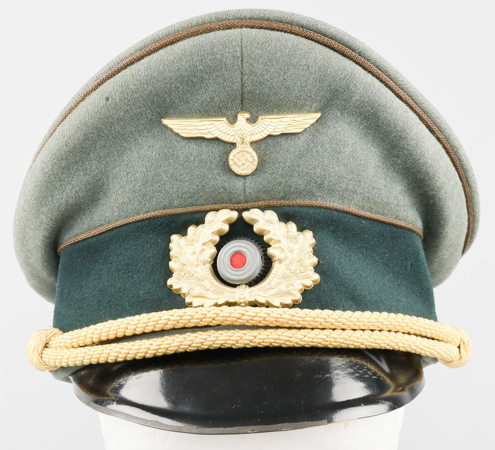 WEHRMACHT GENERAL OFFICER’S VISOR CAP: A fine example of a Wehrmacht General Officer’s visor cap, constructed of greenish-gray wool twill in a high peaked ‘saddle’ shape, over a band of dark green wool, with a black