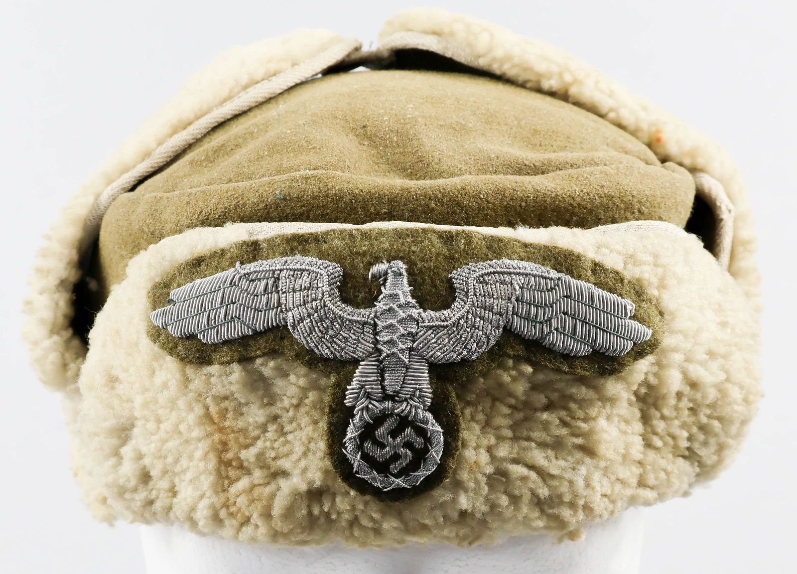 GERMAN GENERAL GOVERNMENT EASTERN COUNTRIES WINTER FUR CAP: Very rare German General Government Eastern Countries Winter Fur Cap, green-brown flat-topped wool body with lamb's wool flaps bearing a loop and button to allow attachment at top. At front is