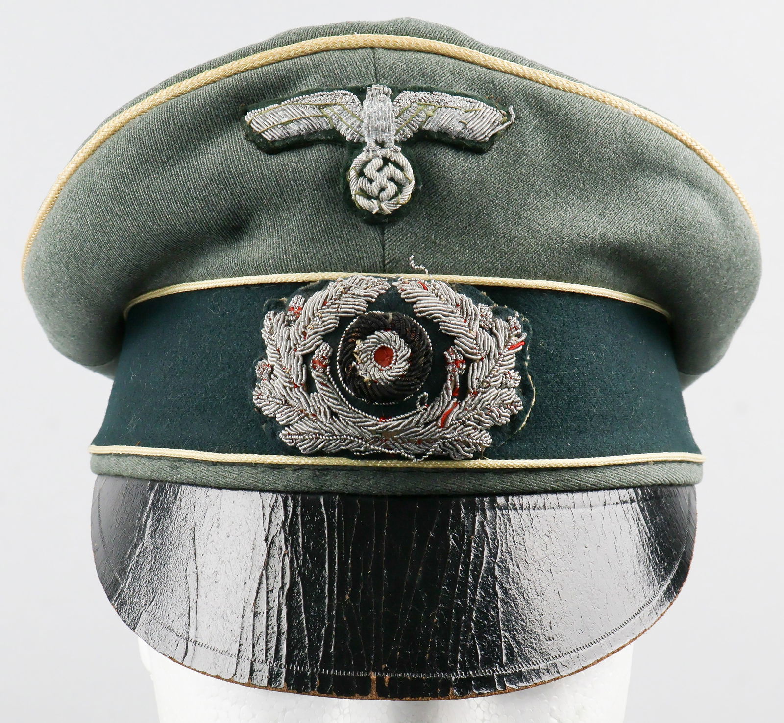 HEER SIGNALS BRANCH 'CRUSHER' VISOR CAP: Scarce, well-used Heer Signals Branch 'crusher' visor cap. The cap has a 'feldgrau' body with forest green sideband, piped in yellow celleon at top and on either side of the sideband indicating a