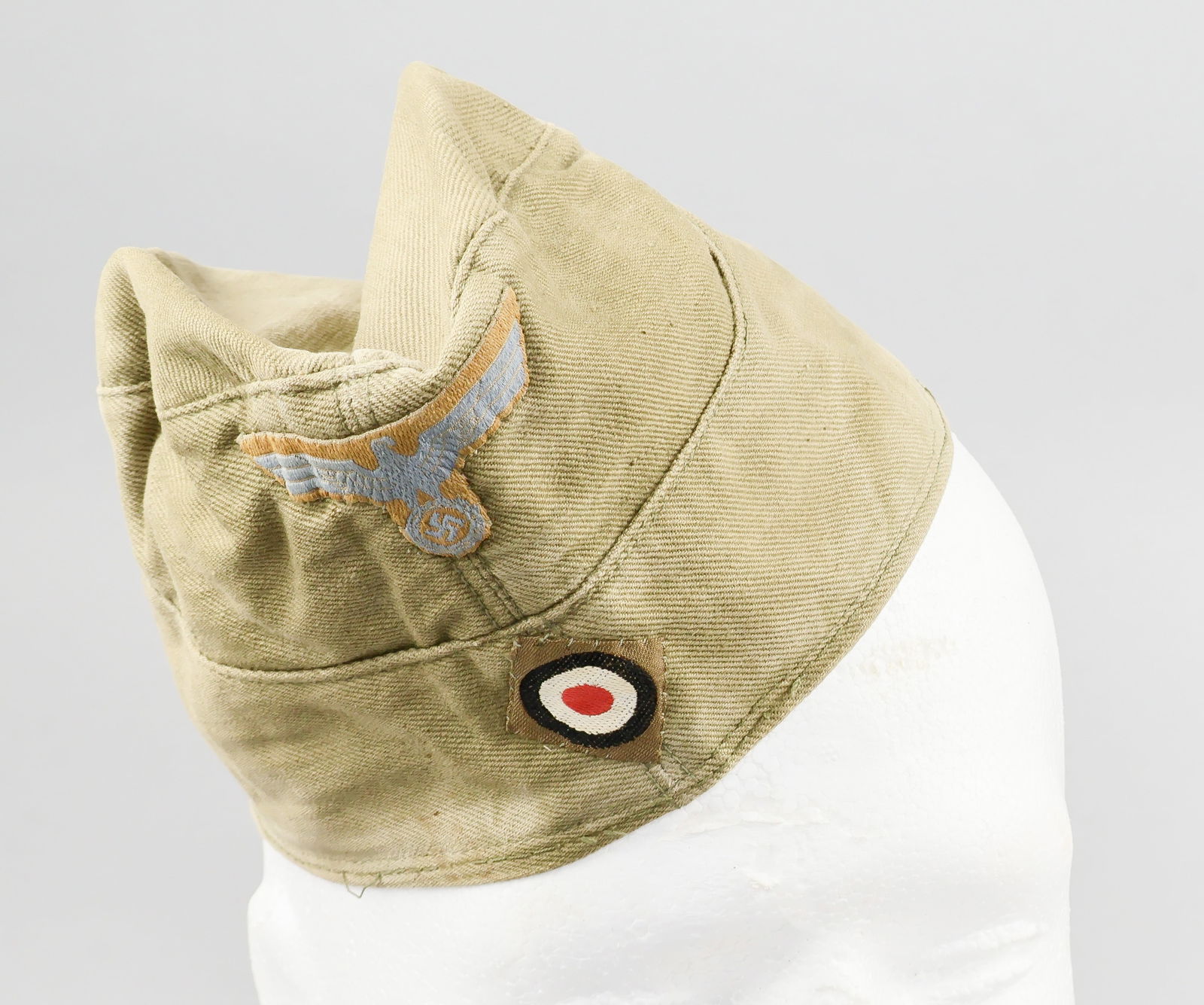 AFRIKA KORPS TROPICAL OVERSEAS CAP: A rare Heer tropical overseas or garrison cap, constructed of olive-brown cotton drill with seam running from the rear edge, over the crown and down the front, and with two integral flaps sewn to