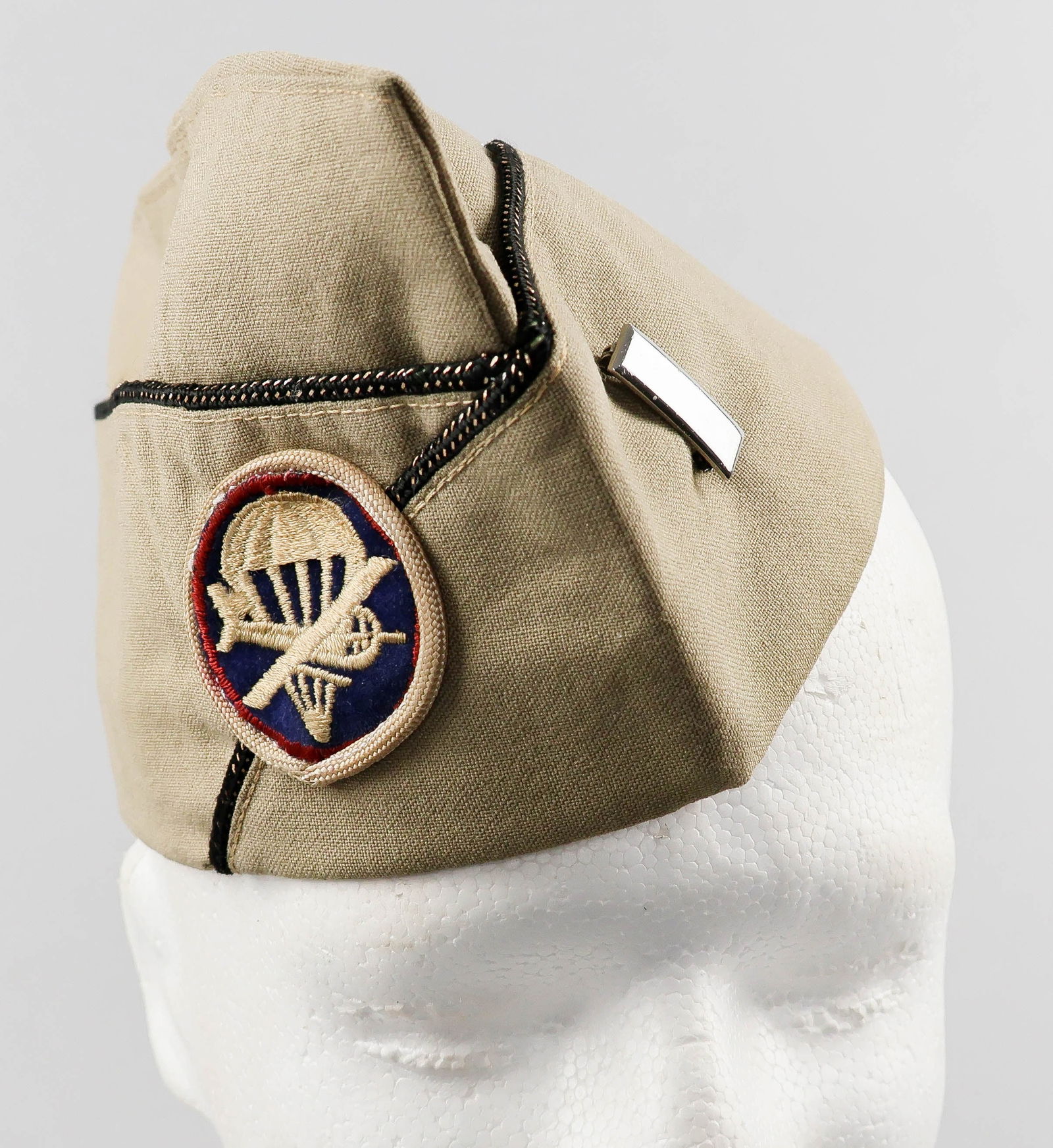 AMERICAN GLIDER OFFICER'S GARRISON CAP: A world War II American glider officer's cap with patch, black piping with gold wire interwoven, a lieutenant's bar pinned to one side, the opposite bearing an infantry glider patch further adorned