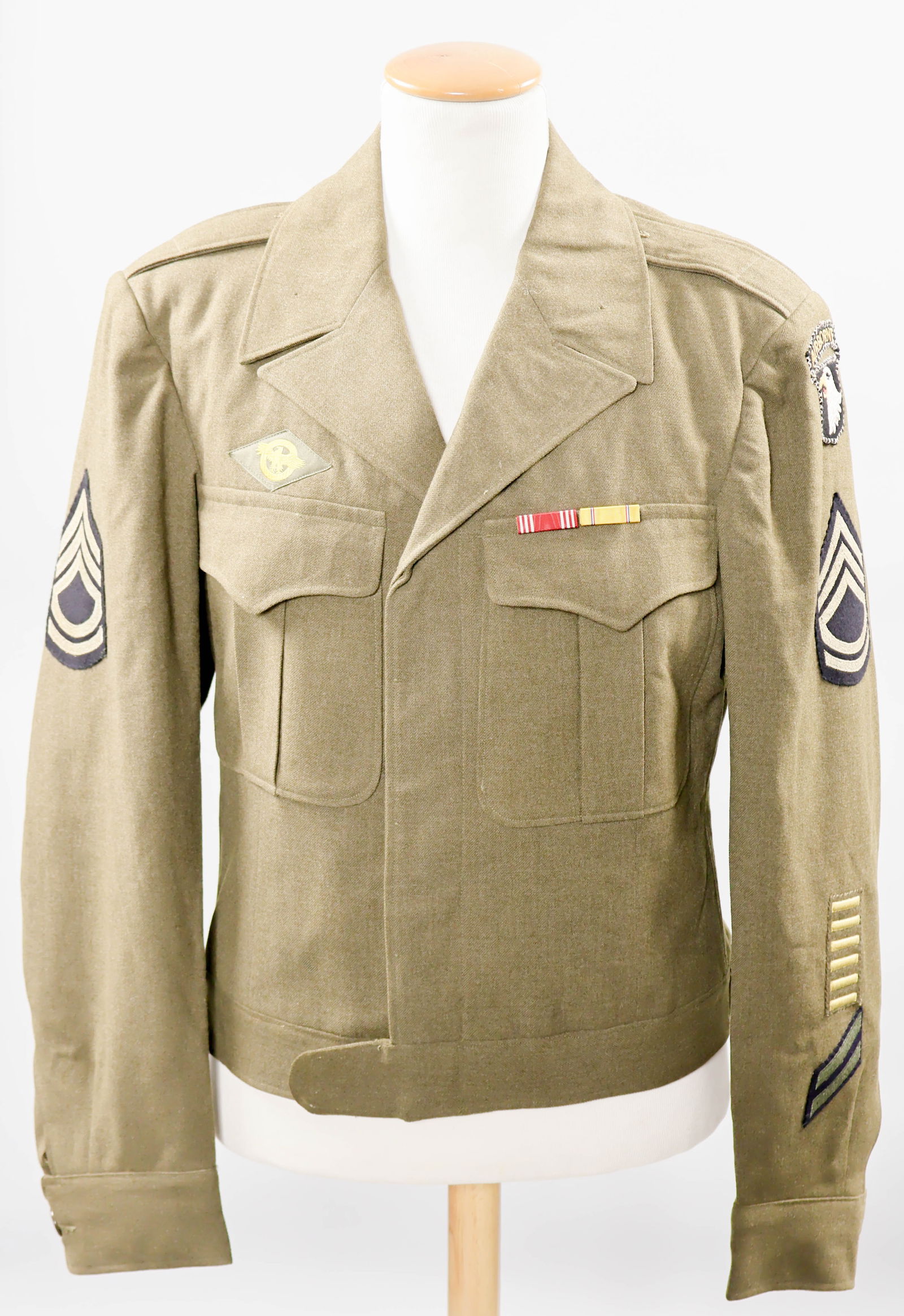 101ST AIRBORNE DIVISION ‘IKE’ JACKET: U.S. M1944 ‘Ike’ uniform jacket, displaying the embroidered felt ‘Screaming Eagle’ insignia patches of the famous 101st Airborne Division on the left-hand shoulder, this