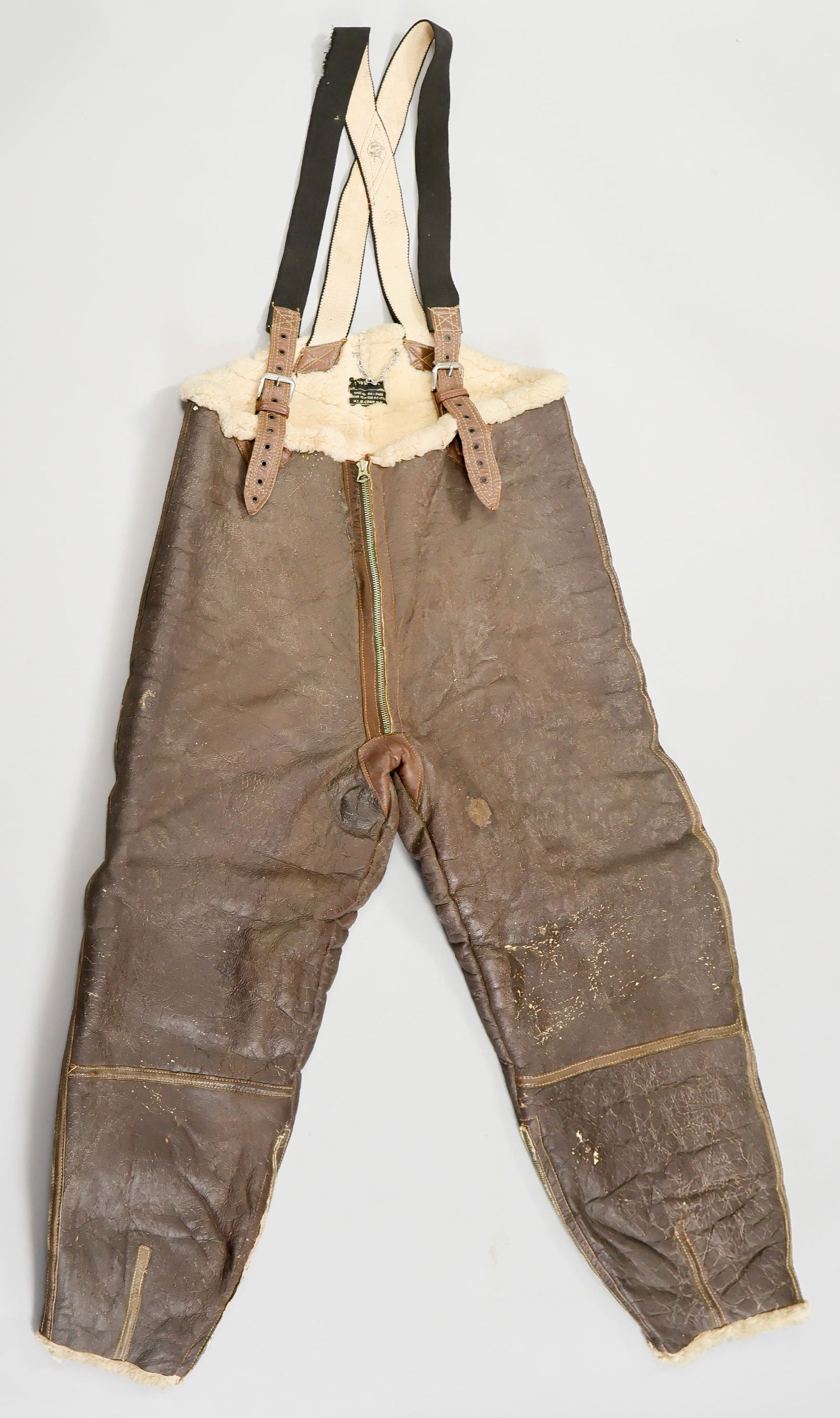 A.A.F. AIR CORPS B-1 SHEEPSKIN FLIGHT PANTS, IDENTIFIED: Pair of World War II A.A.F. B-1 Sheepskin Flight Pants with suspenders, very good condition, very good condition with only minimal chipping to the brown finished facing. The pants are named in