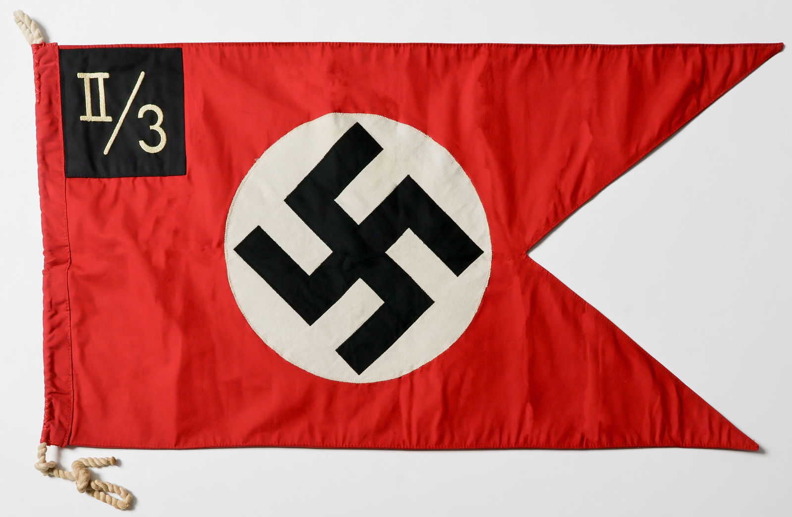 S.A. REITER CAVALRY PENNANT: Very rare S.A. Reiter Cavalry Pennant, 31 x 17 in., two-sided red cotton 'swallowtail' body with separate ribbed white center discs and black swastikas, both sewn with zig-zag machine stitching.