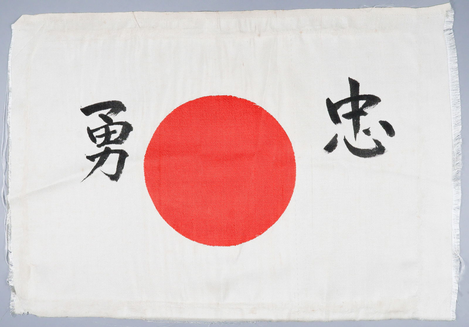JAPANESE SOLDIER'S GOOD LUCK FLAG: Simply inscribed very high quality Japanese soldier's 'good luck' national flag, silk construction, 19 x 13.5 in. with the center red Japanese 'meatball' sun symbol interwoven into the flag itself.