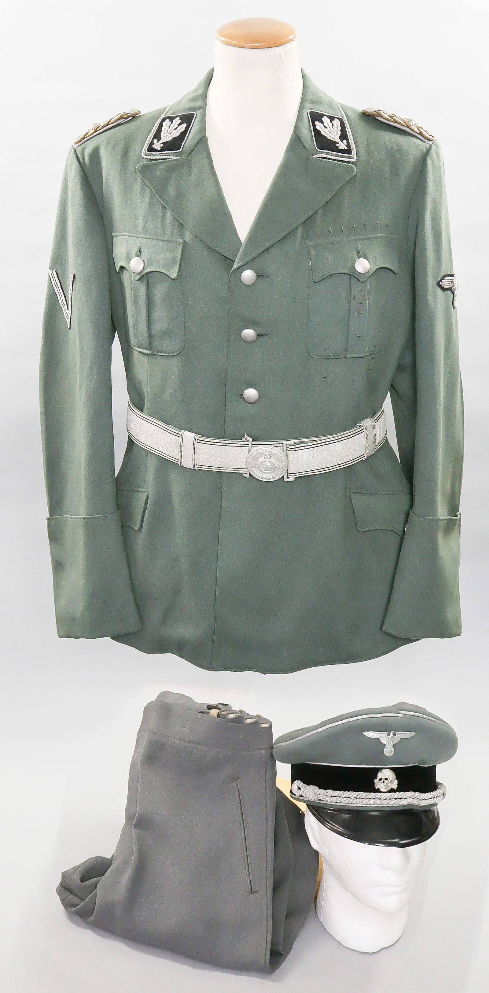 SS UNIFORM AND VISOR CAP OF HANS BAUR, HITLER'S PERSONAL PILOT: HANS BAUR (1897-1993) World War I flying ace, SS officer and personal pilot to German dictator Adolf Hitler. Presented here are a pair of historic uniform items belonging to one of Hitler's closest