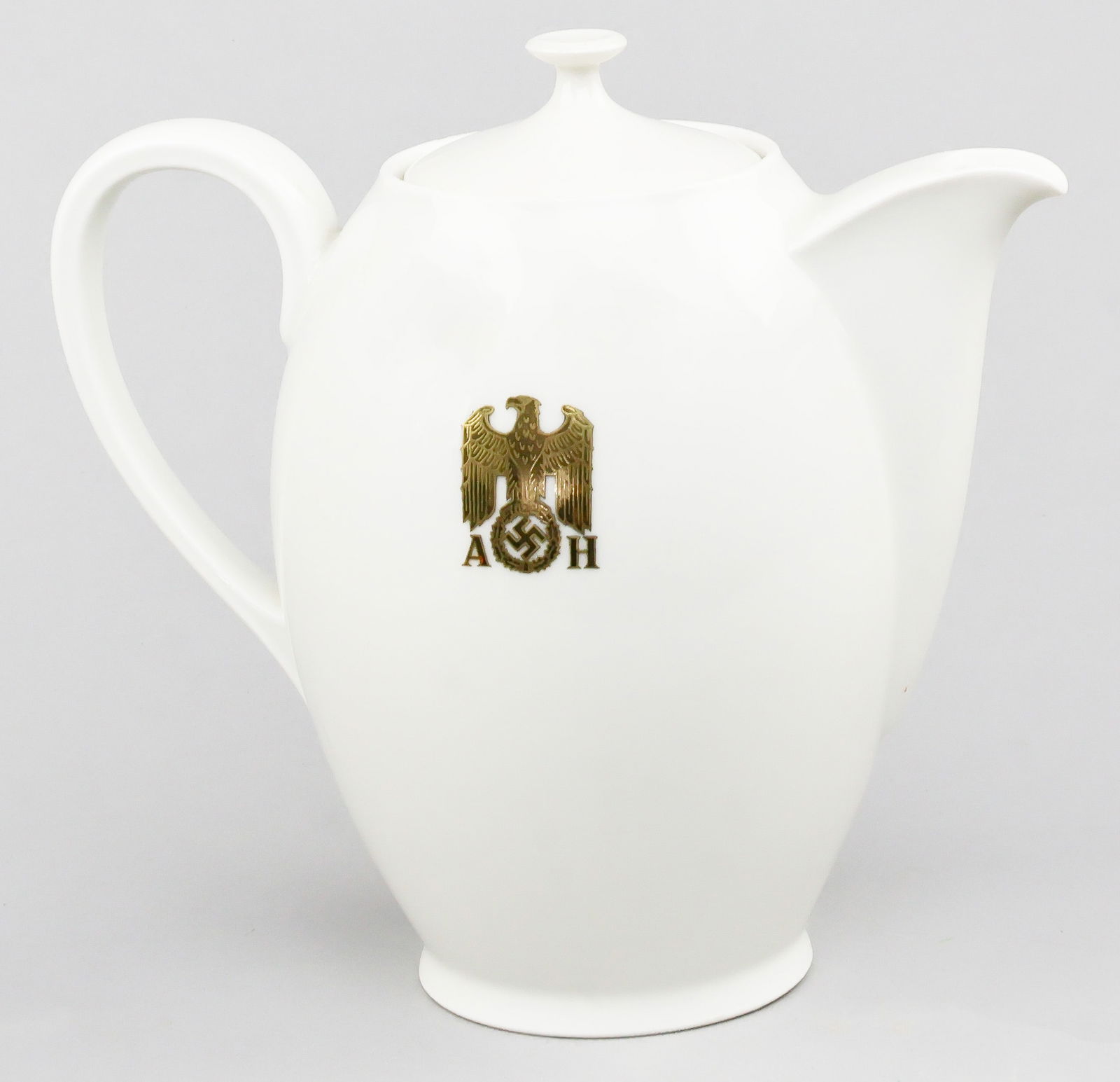 ADOLF HITLER MONGRAMMED COFFEE POT BY ALLACH: Rare white porcelain coffee pot, approx. 8.75 in. tall with lid, bearing on two sides a gilt droop-winged eagle and swastika on the rim, flanked by the gilt initials 'A H.' The base bears the