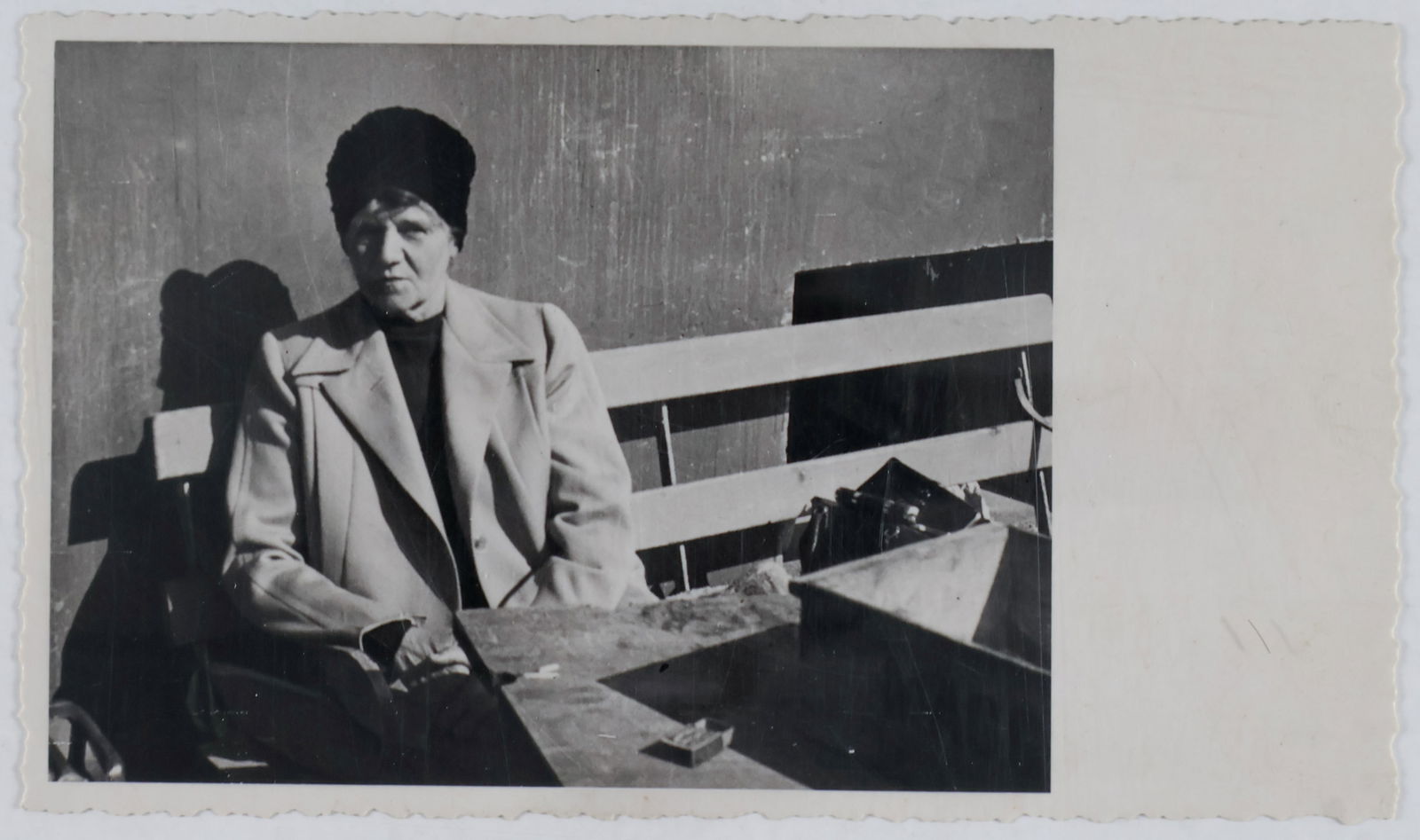 (ANGELA HITLER): A vintage real-photo postcard, 5 x 3 in., from the estate of Angela Hitler, probably unpublished, showing Angela Hitler seated on a bench in a disorderly setting. Fine. Angela Hitler